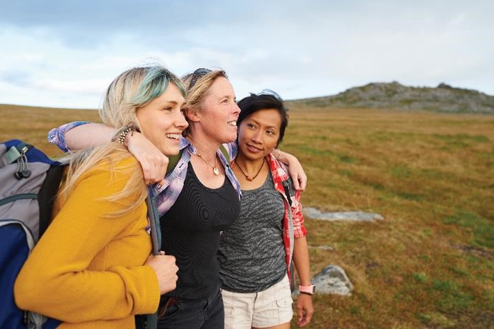 Tres mujeres sonriendo durante una caminata