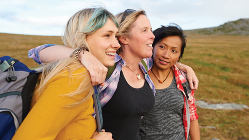 Three women on a hike in nature.