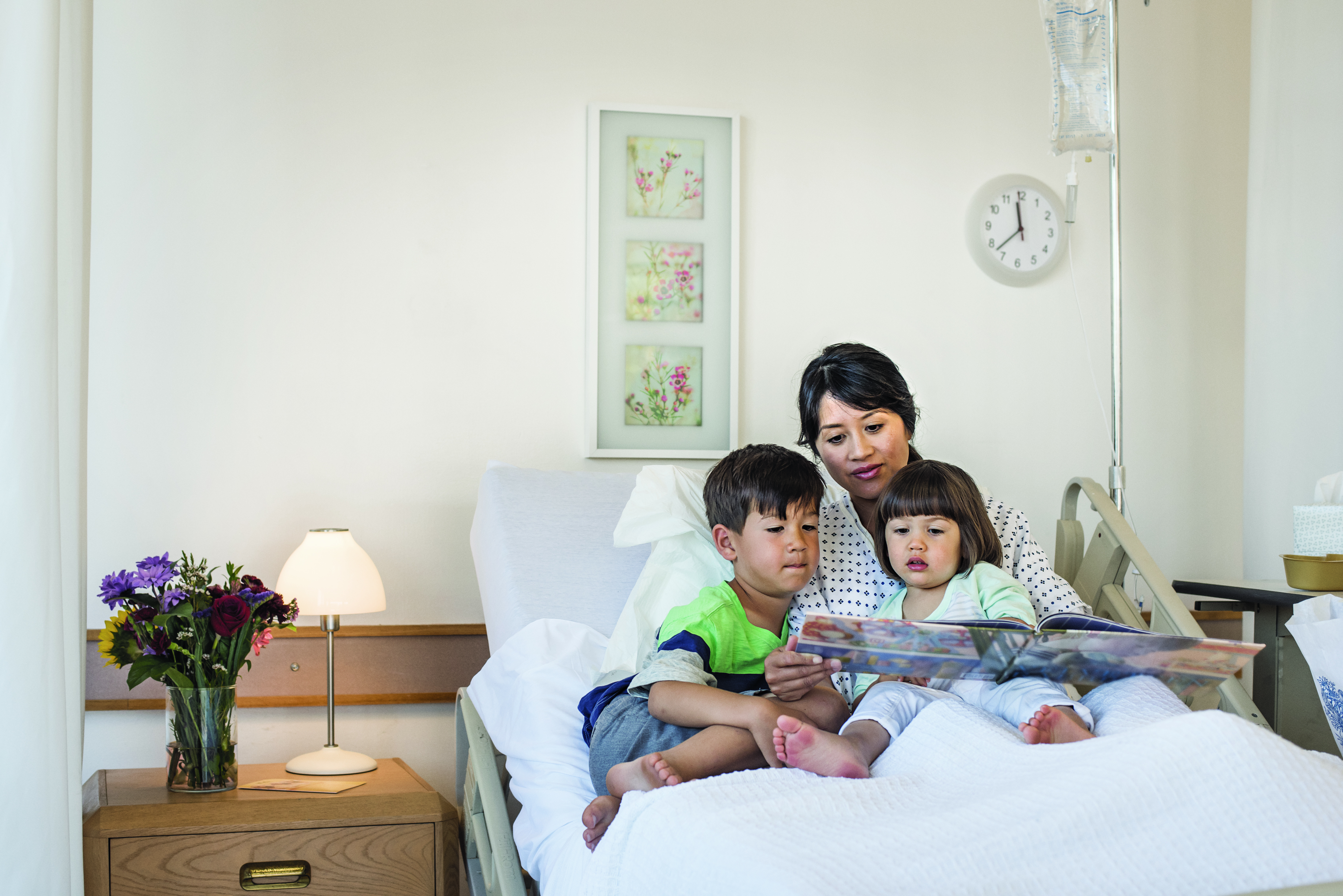 A woman reading to her children in bed