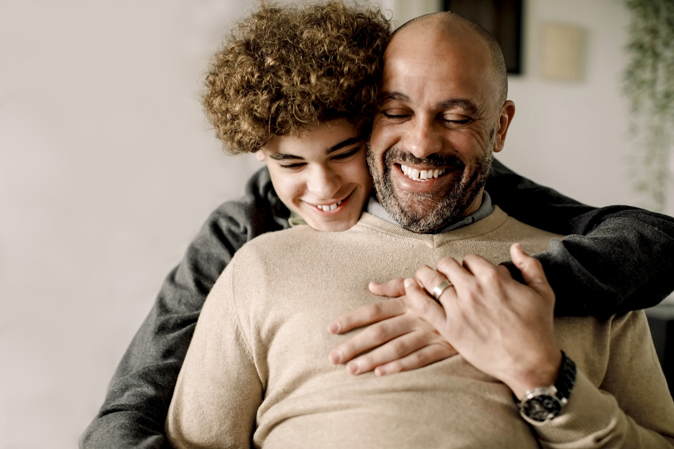Happy, smiling father and son embracing