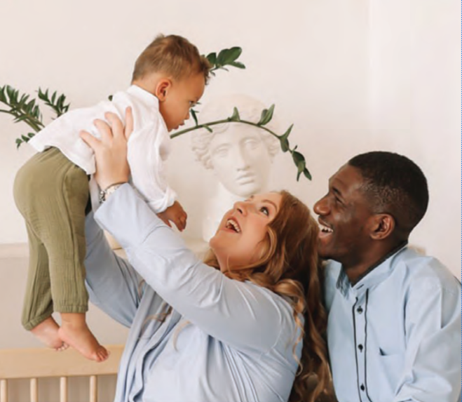 Happy, smiling couple playing with their baby