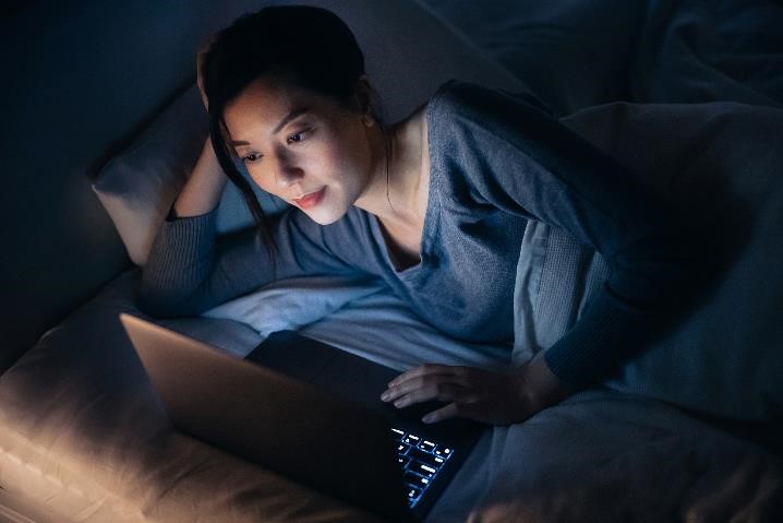 Woman looking at computer in dark room